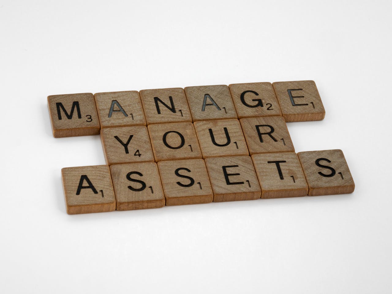 Wooden tiles spelling Manage Your Assets offer conceptual business advice.